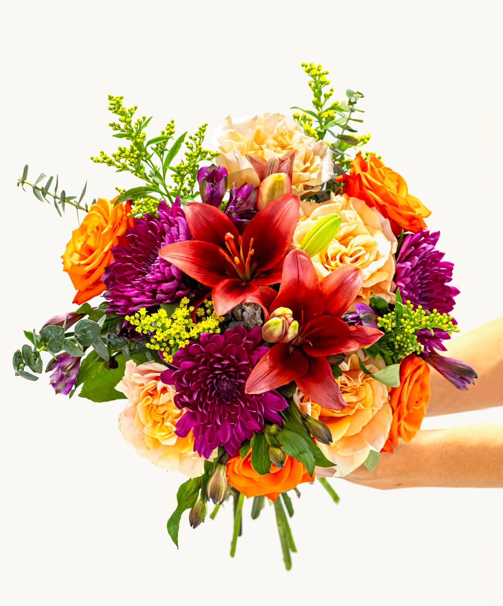 Vibrant floral bouquet featuring orange roses, lilies, and purple dahlias, perfect for gifts.